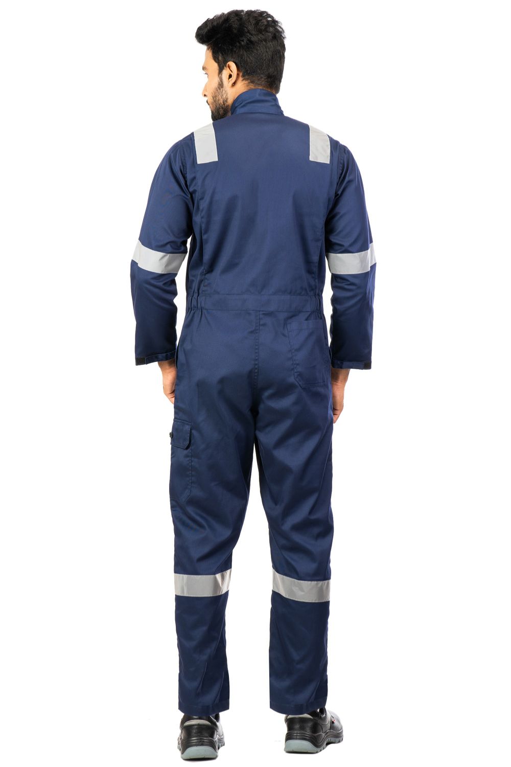 Man wearing navy blue industrial coverall with reflective bands on shoulders, arms, and legs, back view