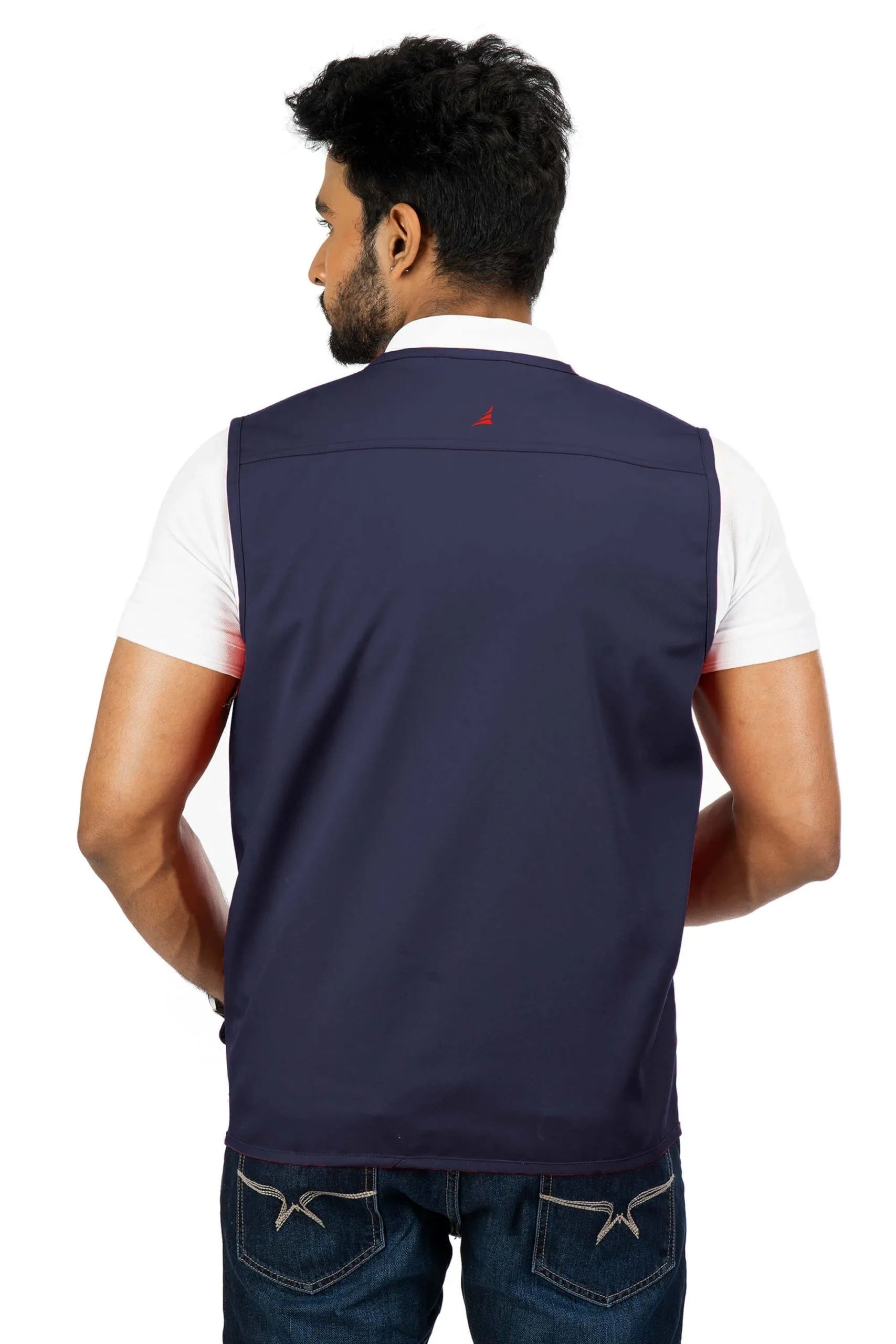Man wearing navy blue multi-utility safari vest in cotton blend twill, back view, over white short-sleeve shirt