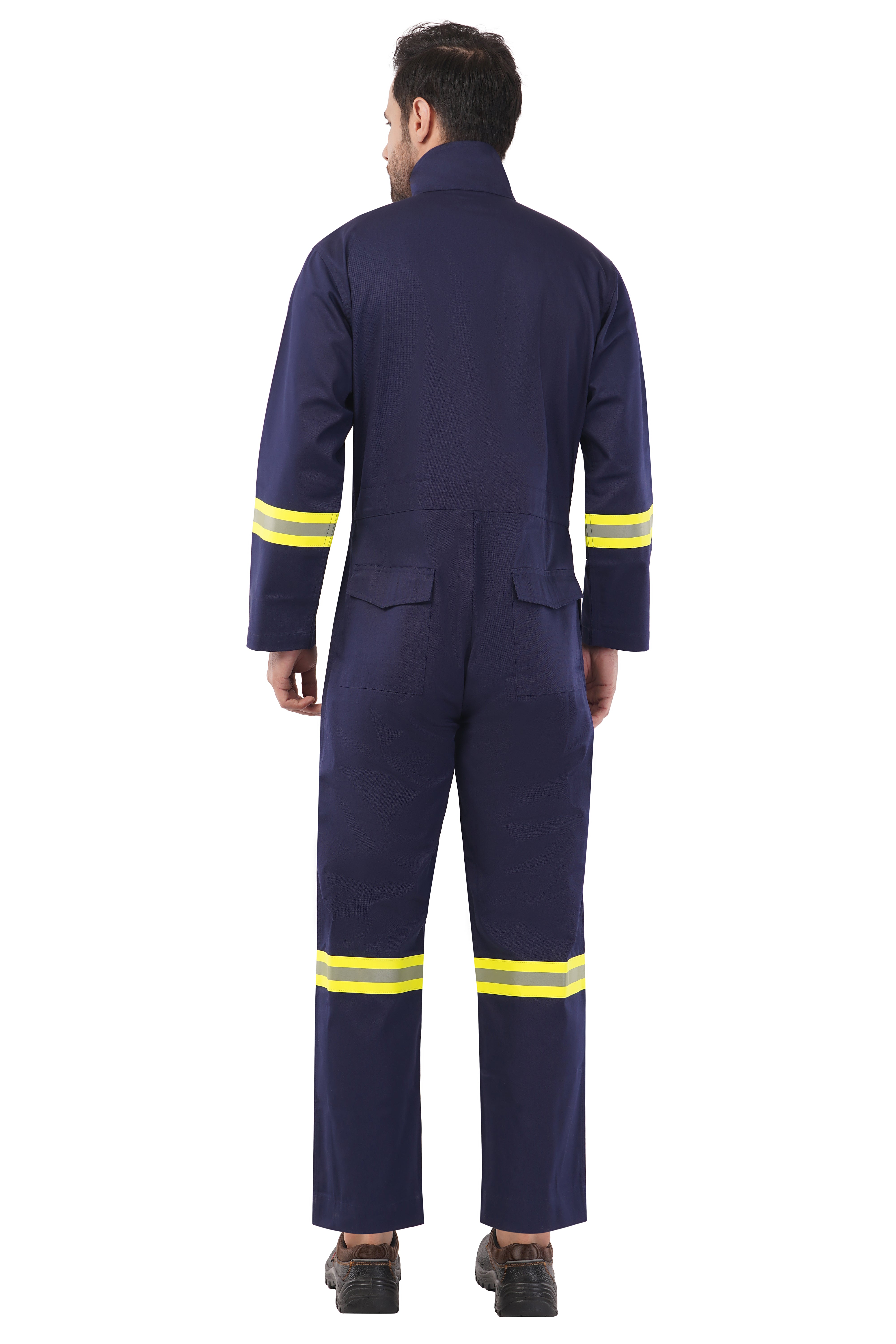 Man wearing navy blue industrial coverall with yellow reflective stripes on sleeves and legs, back view, flap pockets