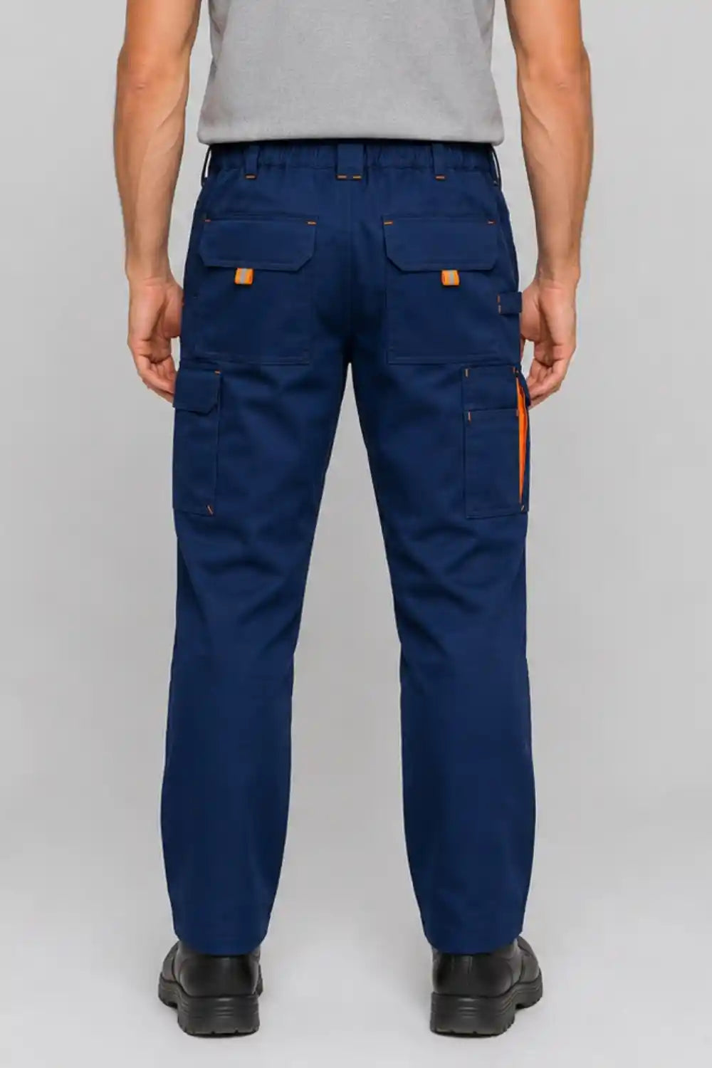 Person wearing blue work pants with orange accents on a white background