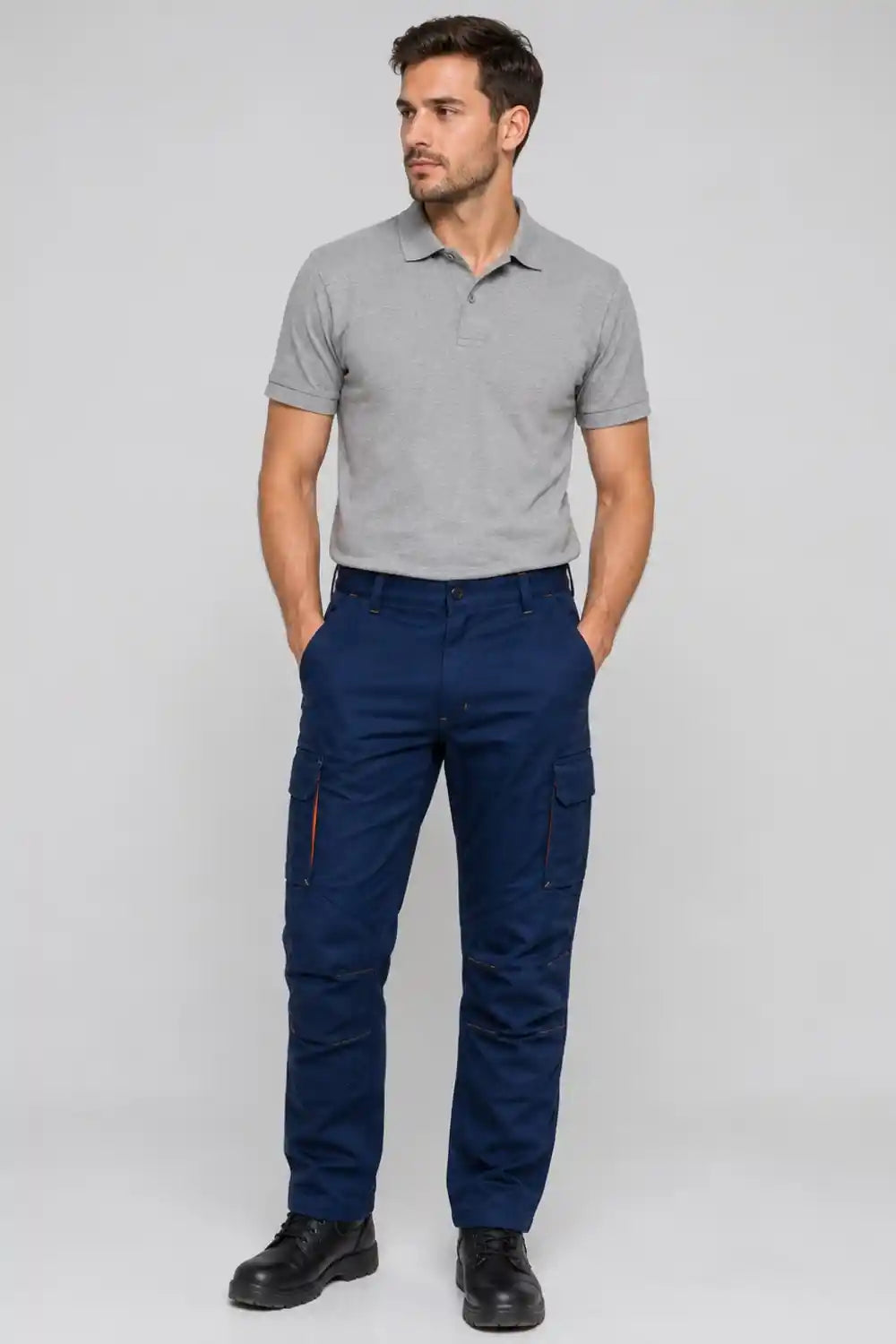 Man wearing a gray polo shirt and navy pants on a white background