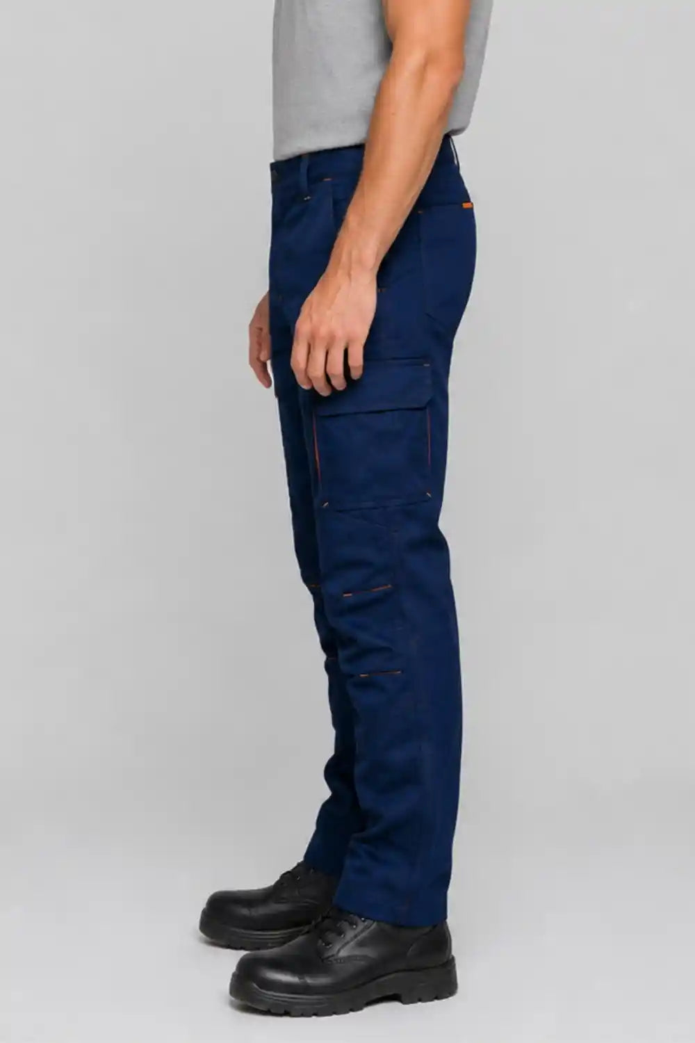 Person wearing navy blue cargo pants on a gray background