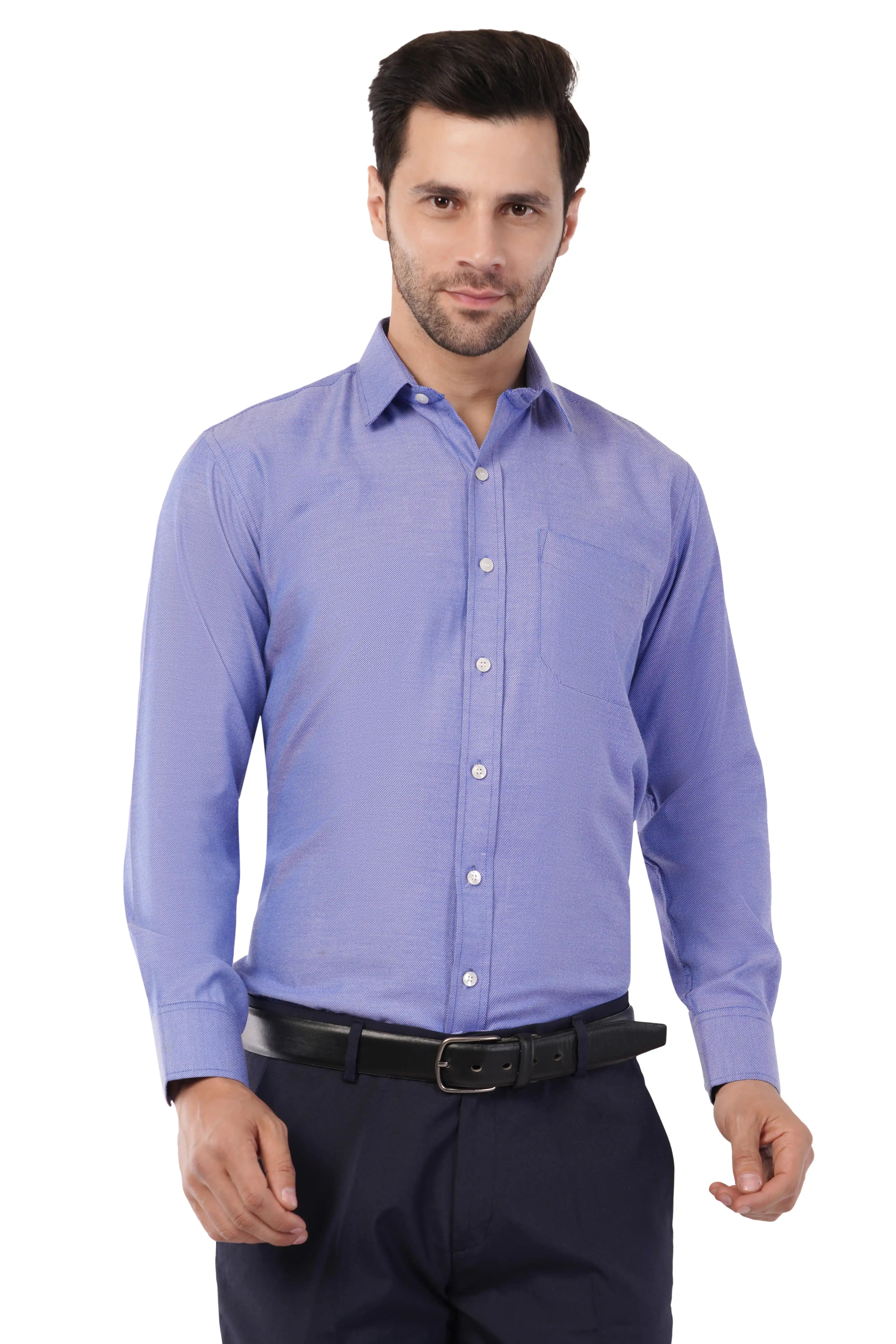 Man wearing a light blue dress shirt from Atacama and dark pants on a white background