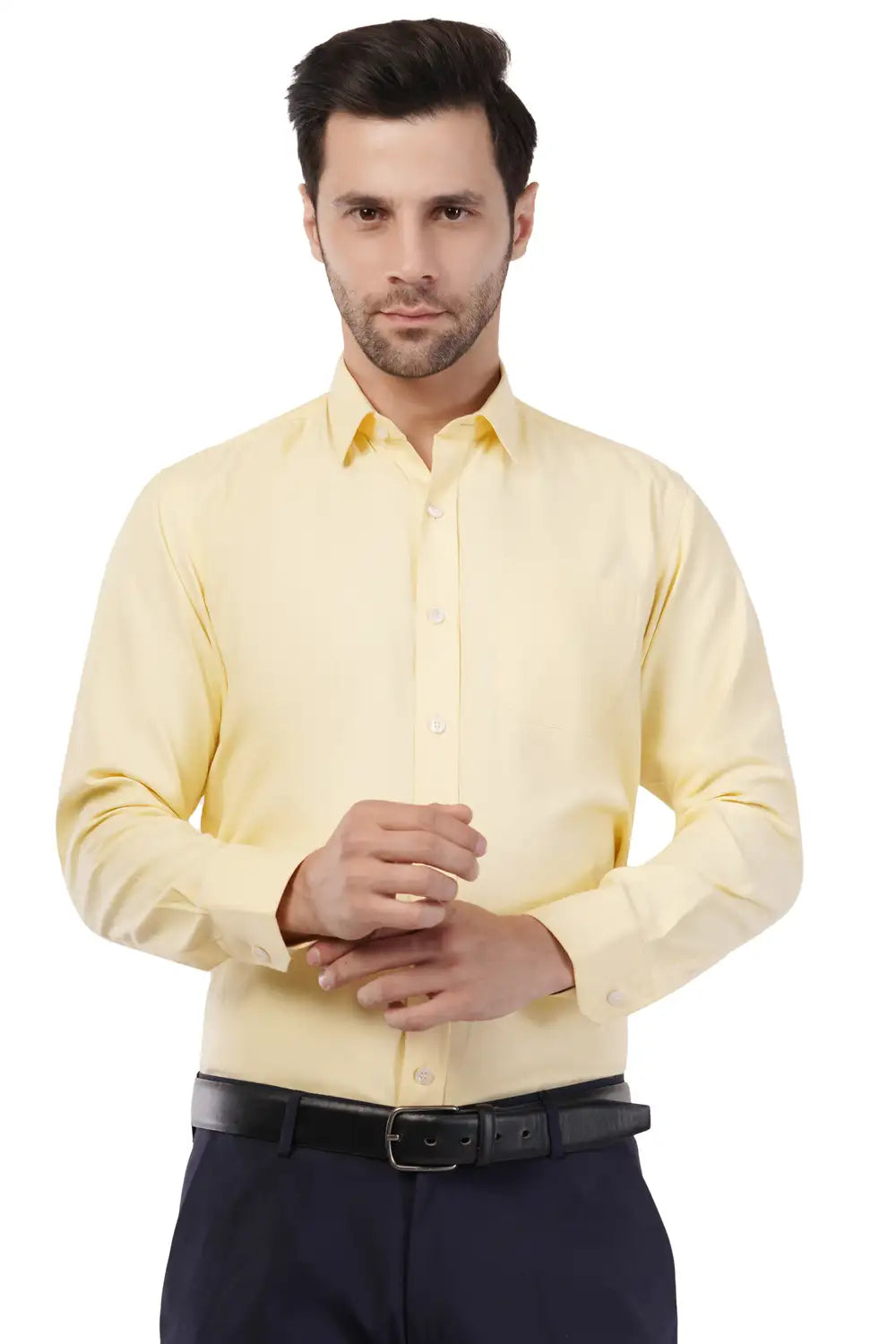 Man wearing a light yellow Atacama shirt and dark pants on a white background