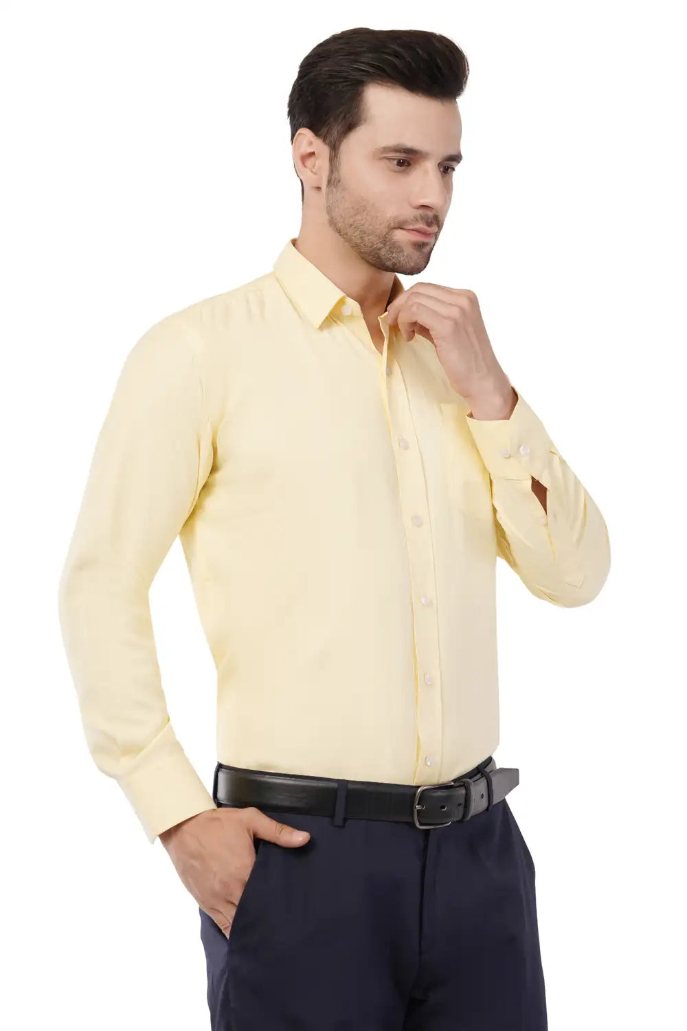 Man wearing a light yellow Atacama dress shirt and dark pants on a white background