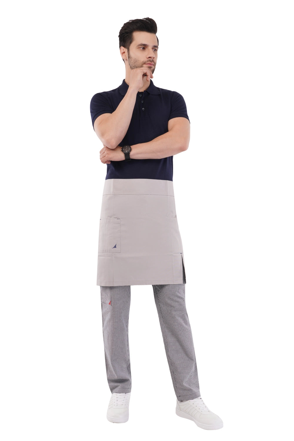 Man wearing a dark polo shirt, gray Atacama apron, and gray chef pants on a white background