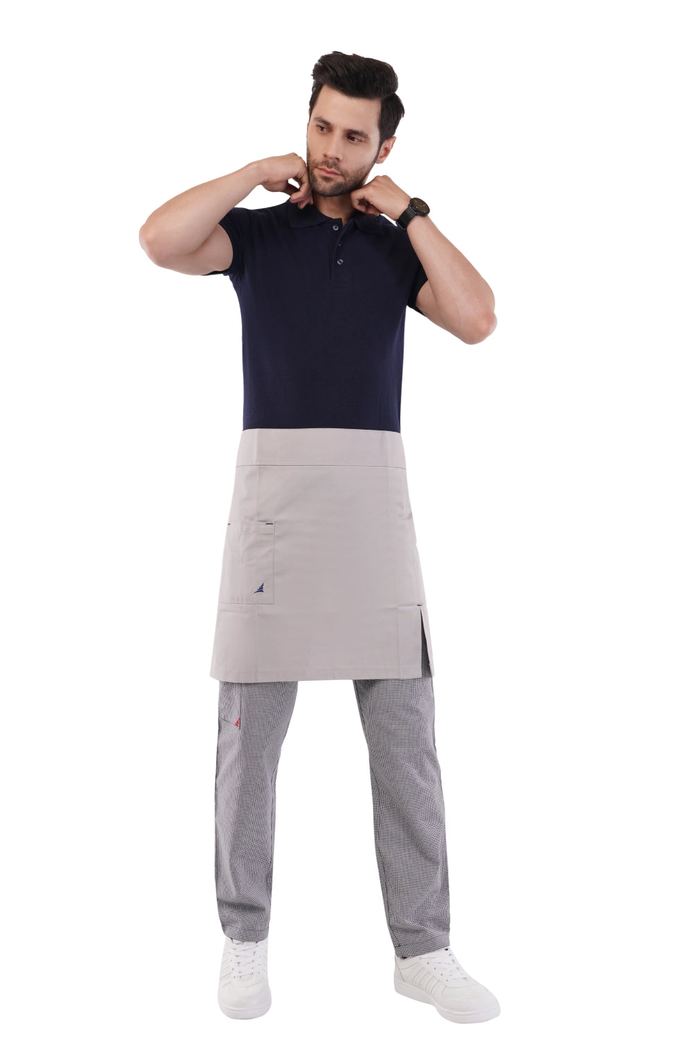Man wearing a dark blue shirt and gray Atacama apron on a white background