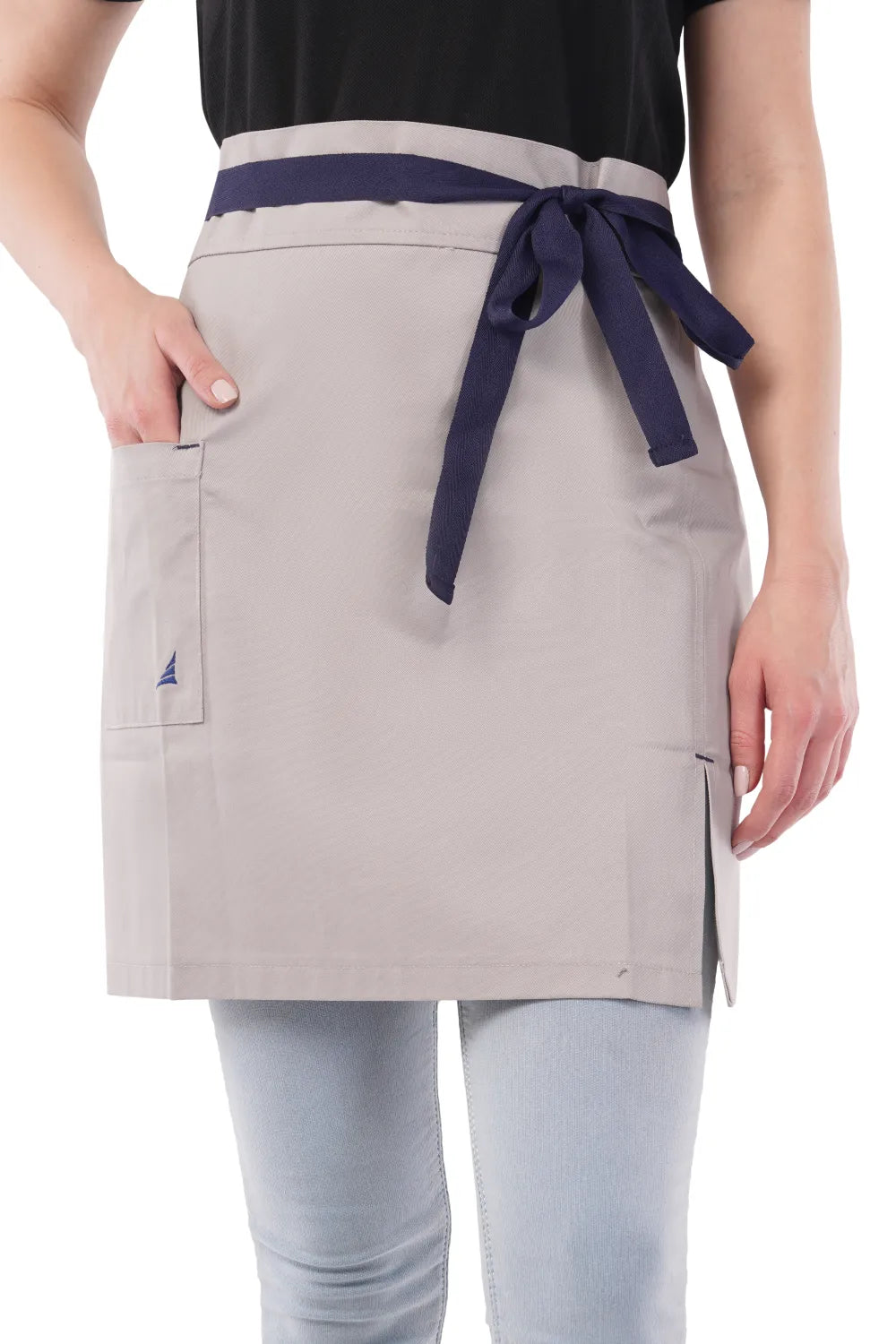 Person wearing a gray Atacama apron with a navy belt on a white background
