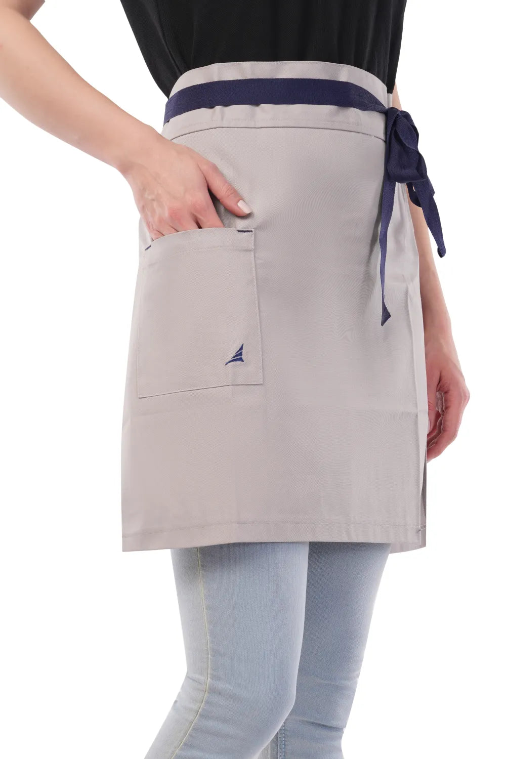 Person wearing a gray Atacama apron with a pocket on a white background